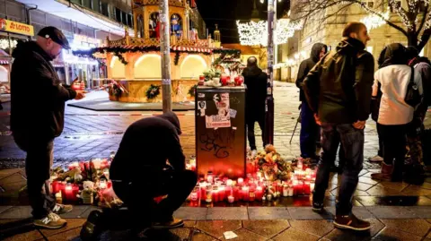 EPA Flowers and candles next to the Christmas market in Magdeburg, Germany, 21 December 2024.