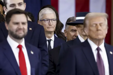 EPA-EFE/REX/Shutterstock Tim Cook standing behind JD Vance and Donald Trump