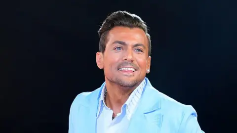 PA Paul Danan smiling in a turquoise suit