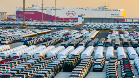 Getty Images A ro-ro ship of clean energy vehicles, ''BYD Hefei,'' loads new energy vehicles for export to Zeebrugge Port in Belgium at Haitong (Taicang) Automobile Terminal in the Taicang Port district of Suzhou Port in Suzhou, China, on January 11, 2025.