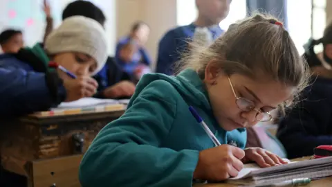 Reuters Syrian children study at a school in Damascus, Syria (19 December 2024)