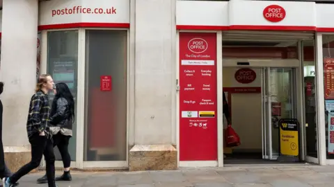 Getty Images People walking outside a Post Office in London