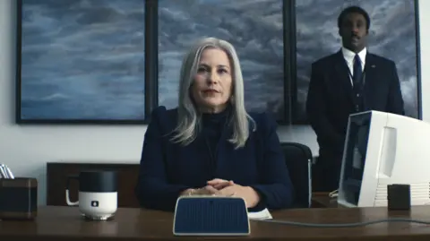 Apple TV Patricia Arquette as Harmony Cobel, sitting in the the floor manager's office