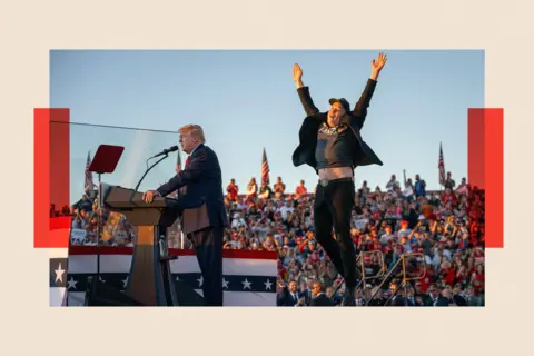 Getty Images Elon Musk jumps on stage as Donald Trump gives a speech at a rally