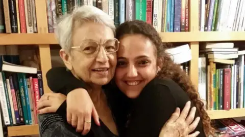 Reuters / Handout Family handout photo of Romi Gonen hugging her grandmother. Both are embracing and smiling at the camera, infront of a bookshelf