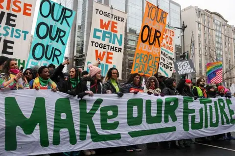 Getty Images Protesters hold a banner that reads 