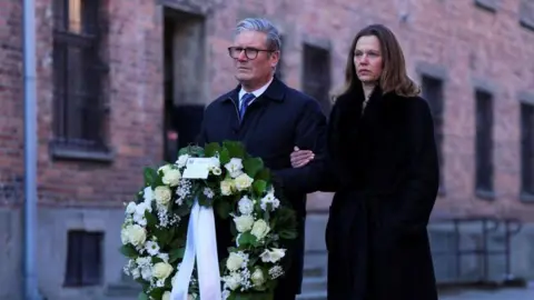 PA Media Prime Minister Sir Keir Starmer and his wife Lady Victoria, wait to lay a wreath during their visit to the Memorial and Museum Auschwitz-Birkenau, a former German Nazi concentration and extermination camp, in Oswiecim, during his visit to Poland to begin talks on a new defence and security agreement. Picture date: Friday January 17, 2025.