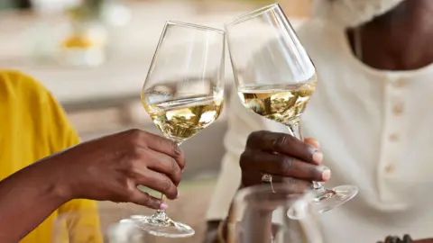 Getty Images Two people clinking their wine glasses