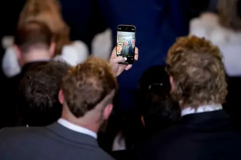 Getty Images Sam Altman takes a photo on his phone of him, Jake and Logan Paul