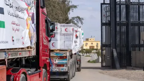 Getty Images Trucks loaded with aid enter through the Rafah Border Crossing on the morning of Sunday 19 January