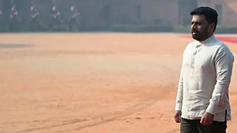 Getty Images Anura Kumara Dissanayake in a white shirt walking during his ceremonial reception at the presidential palace Rashtrapati Bhavan in New Delhi