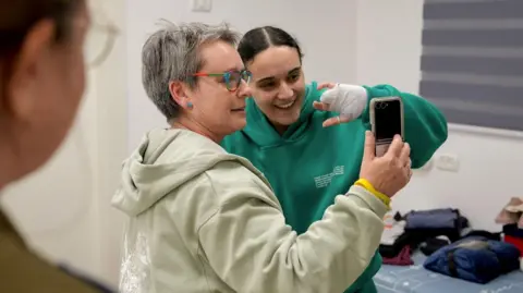 Reuters Hostage Emily Damari, an Israeli-British citizen, with her mother Mandy at an Israeli military base on Sunday after being released