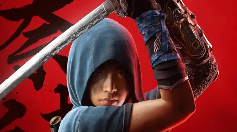 Ubisoft A female ninja character stands in front of a blood-red background with Japanese calligraphy characters daubed across it. Her eyes are just visible underneath her blue hood and she holds a katana above her head, ready to strike.