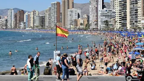 Getty Images Tourists on a beach in Benidorm