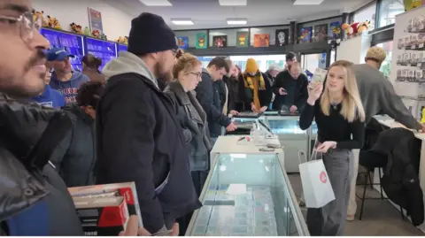 YouTube/PokiChloe A still from one of PokiChloe's video shows a busy shop packed with people as Chloe and Dean try to serve customers