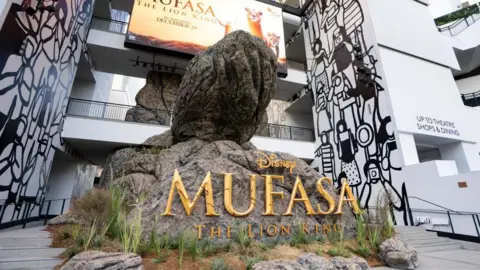 Getty Images A picture of the outside of a cinema where a promotional sculpture carries text promoting Disney Mufasa The Lion King  