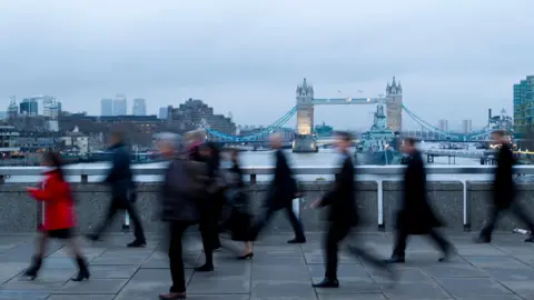 Getty Images Blurred images of workers crossing London Bridge, with Tower Bridge in the background