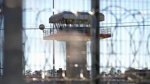 BBC/Lee Durant A concrete watchtower is seen through barbed wire on the perimeter fence at Estelle Supermax Penitentiary