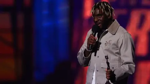 Getty Images Myles Smith on stage with his Brit award for rising star