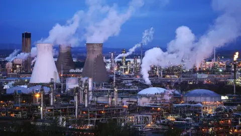 PA Media The chimneys and pipes at the Grangemouth plant illuminated by lights