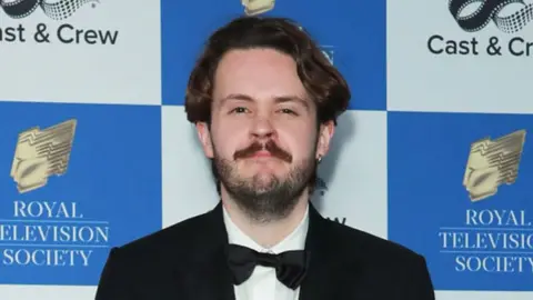 Getty Images Nick Stapleton attends the Royal Television Society Programme Awards at The Grosvenor House Hotel on March 26, 2024, London. He has dark hair and a dark beard and is wearing black tie.