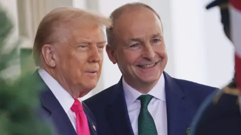 POOL/EPA-EFE/REX/Shutterstock Donald Trump and Micheál Martin standing next to each other. Both men are wearing suits. Donald Tump has a red tie and Micheál Martin a green one