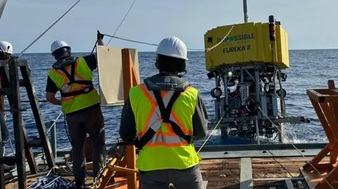 Impossible Metals Crew lower a mining machine from Impossible Metals into the sea.