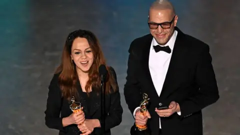 Getty Images TOPSHOT - Iranian animator and film director Shirin Sohani (L) and Iranian animator Hossein Molayemi accept the award for Best Animated Short Film