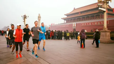 Mark Zuckerberg / Facebook Mark Zuckerberg running in Tiananmen Square, Beijing, China. He is wearing a grey T-shirt and black shorts. And is accompanied by at least five other runners. The photo was first posted in 2016 on Mr Zuckerberg's social media.