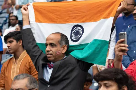 AFP A man holds up the flag of India as US President Donald Trump and Indian Prime Minister Narendra Modi attend 