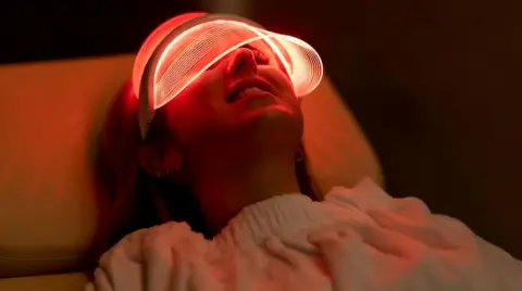 Getty Images Woman lying down with an LED mask covering her face with a red glow