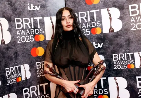 Getty Images Charli XCX poses with her Brit Awards