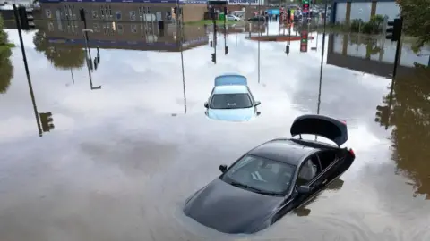 Getty Images Cars floating in floodwater in Derby after the River Derwent burst its banks during storm Babet on October 21, 2023.